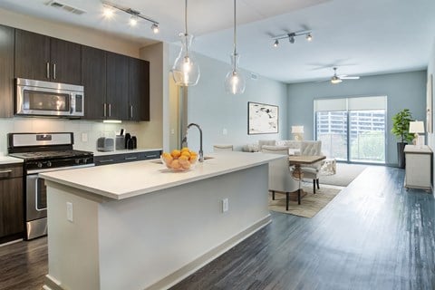 a kitchen with a large island and a living room with a table